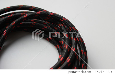 Part of a circular winding of cable with a synthetic braided protective layer. Cable and wire detailed stock photo 132140093