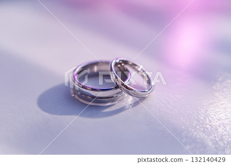 Beautiful Wedding Rings Reflecting Light on a Smooth Surface, Perfect for Symbolizing Love and Commitment 132140429