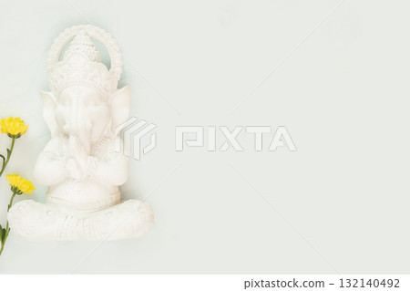 Sculpture of Lord Ganesha with flowers on a light blue background with copy space. Holiday of Ganesh Chaturthi. Ganesh festival. Hindu religion holidays. Flat lay Sculpture of Lord Ganesha with flowers on a light blue background with copy space. Holiday of Ganesh Chaturthi. Ganesh festival. Hindu religion holidays. Flat lay 132140492