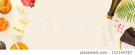 Rosh hashanah, Jewish New Year holiday. Rosh hashanah banner with traditional symbols, apples, honey, carrots, hala and table setting with bottle of champagne and gift. Banner size, copy space 132140787