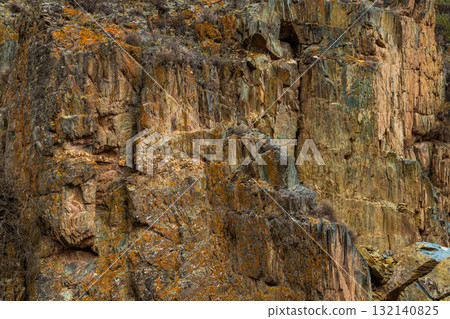 Textured rock formation in rugged mountainous environment 132140825