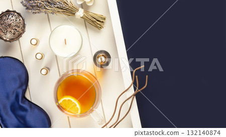 Self-care flat lay with blue sleeping mask, lavender flower, herbal tea, and natural oils on a white wooden tray with copy space. Concept of Me time and no depression. Remedy for healthy sleep 132140874