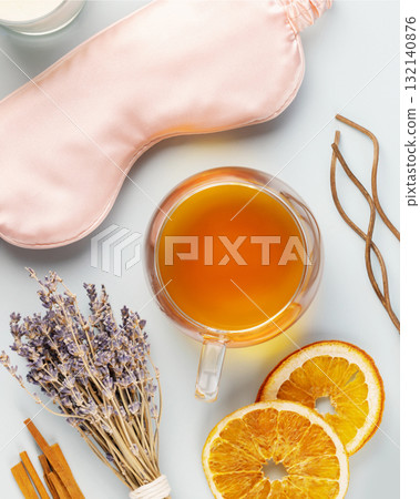Self-care flat lay with sleeping mask, lavender flower, herbal tea, dry oranges and aroma sticks on a blue background. Concept of Me time and no depression. Healthy sleep is healthy life 132140876