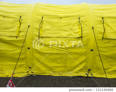 Worn yellow tarp with closed window covers at overcast day, full-frame close view 132140980