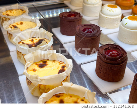 Assortment of chocolate and cheesecake desserts arranged in neat rows. Variety of forms expressing pastry diversity and confectionery artistry. Assortment of chocolate and cheesecake desserts arranged in neat rows. Variety of forms expressing pastry diversity and confectionery artistry. 132141168