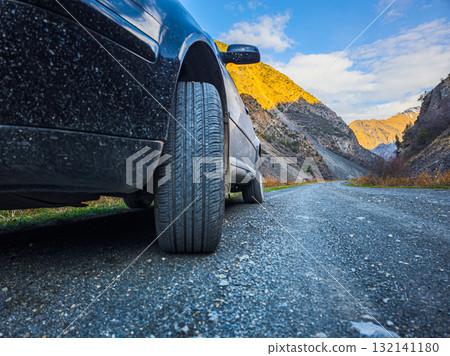 Car parked on gravel road in serene mountainous region Car parked on gravel road in serene mountainous region 132141180