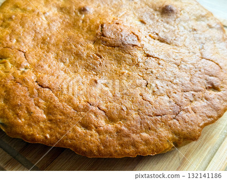 Golden crust with cracks and texture from baking. Warmth, comfort, and homemade simplicity reflecting cozy domestic moments and natural imperfection. Golden crust with cracks and texture from baking. Warmth, comfort, and homemade simplicity reflecting cozy domestic moments and natural imperfection. 132141186