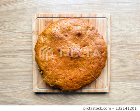 Homemade pie viewed from above on wooden background. Minimalist aesthetic of rustic food photography and homemade dessert tradition. 132141201