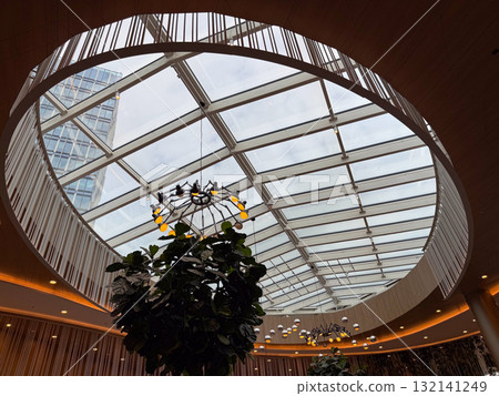 Modern glass ceiling structure in urban architecture. Reflection on transparency, geometry, and natural light as symbols of openness, innovation, and spatial harmony. 132141249