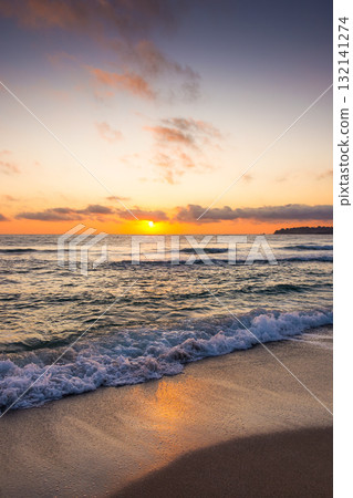 closeup of wave rolling on sandy shore at golden sunrise. cozy bamboo beach of sozopol at the black sea in summer. sun glowing over horizon. beautiful low angle vertical image for travel background closeup of wave rolling on sandy shore at golden sunrise. cozy bamboo beach of sozopol at the black sea in summer. sun glowing over horizon. beautiful low angle vertical image for travel background 132141274