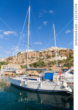 Mgarr marina vertical view taken on a sunny summer day, sailing yacht is moored Mgarr marina vertical view taken on a sunny summer day, sailing yacht is moored 132141334