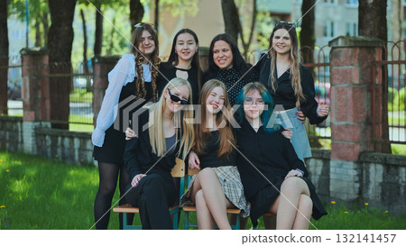 Happy students posing together on a schoolyard bench, enjoying their day at school 132141457
