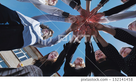Students forming a circle and holding hands to represent unity, teamwork, and school community spirit 132141458