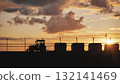 Airport tractor silhouette at sunset with razor wire fence and dramatic clouds 132141469