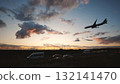 Jet landing at sunset with cars driving on a road near the airport 132141470