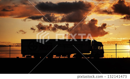 Airport security vehicle patrolling near barbed wire fence at sunset 132141473