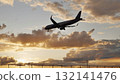 Passenger airplane landing at sunset over airport fence 132141476