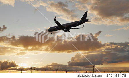 Passenger airplane landing at sunset over airport fence 132141476
