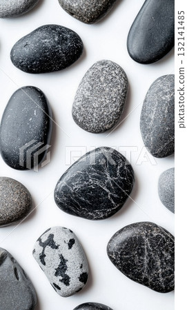 Smooth Black and Gray Stones Arranged on a White Background for Decorative or Design Purposes 132141485