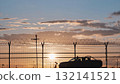 Airport security patrol driving along perimeter fence at sunset 132141521