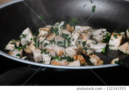Fried chicken pieces with herbs in a pan 132141555