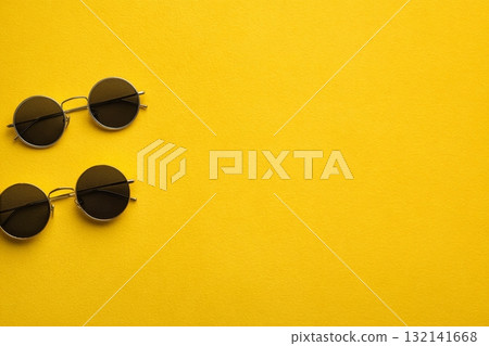 Black Round Sunglasses on a Bright Yellow Background Create a Vibrant Contrast 132141668