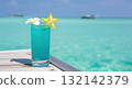 Blue tropical mocktail cocktail on a wooden pier with a beautiful turquoise ocean background 132142379