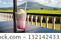Traditional Mauritian Alouda milkshake with a scenic view of a sugar cane field and a mountain 132142433