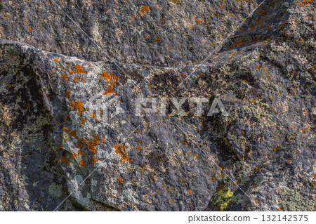 Rugged rock with colorful lichen in natural outdoor setting 132142575