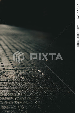 Dark alleyway with wet brick road after rain. A moody, atmospheric shot of the empty brick road leading into the darkness Dramatic city street. Dark alleyway with wet brick road after rain. A moody, atmospheric shot of the empty brick road leading into the darkness Dramatic city street. 132143847