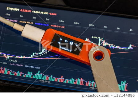 Hardware security key displaying Ethereum on tablet indoors 132144096