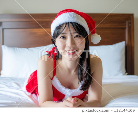 She's lying on the bed dressed as Santa She's lying on the bed dressed as Santa 132144109