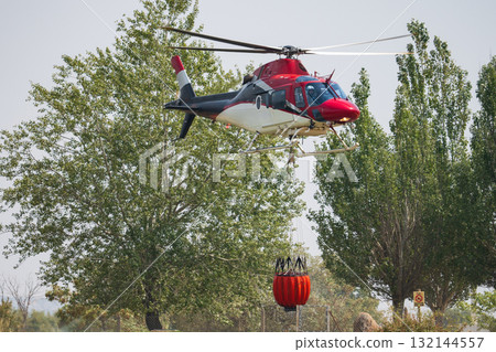 Helicopter Collecting Water from Forest for Firefighting Mission Helicopter Collecting Water from Forest for Firefighting Mission 132144557