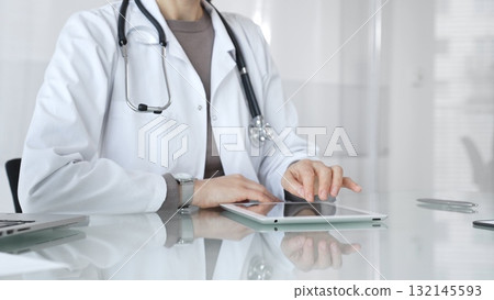 Doctor using digital tablet for remote medical consultation, providing modern healthcare services, telehealth concept. Medicine and health care 132145593