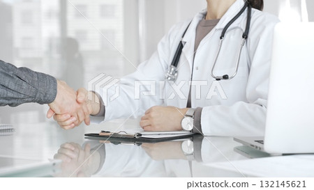 Doctor and patient hands shaking, symbolizing trust, agreement, healthcare partnership, successful consultation, and medical service. Medicine and health care Doctor and patient hands shaking, symbolizing trust, agreement, healthcare partnership, successful consultation, and medical service. Medicine and health care 132145621