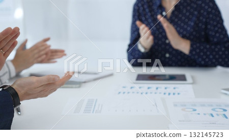 Business team applauding after successful presentation during a meeting in the office, celebrating achievement and good teamwork with positive attitude 132145723