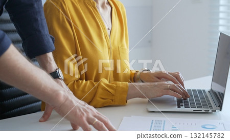 Colleagues are collaborating on a project, analyzing financial charts and using a laptop to input data, working together to achieve their business goals. Business people concept Colleagues are collaborating on a project, analyzing financial charts and using a laptop to input data, working together to achieve their business goals. Business people concept 132145782