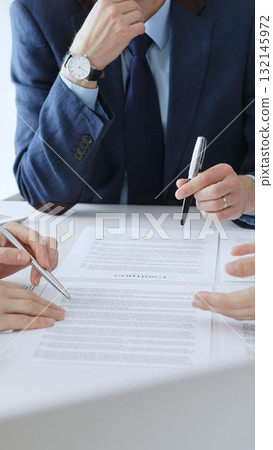 Businesspeople hands with pens reviewing documents and engaging in a discussion across a table, representing contract signing, legal consultation, negotiation, and important agreement collaboration Businesspeople hands with pens reviewing documents and engaging in a discussion across a table, representing contract signing, legal consultation, negotiation, and important agreement collaboration 132145972