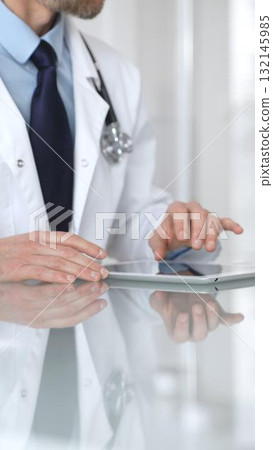 Doctor using digital tablet, consulting with patient, working in healthcare office, telemedicine and medical technology concept. Medicine and health care Doctor using digital tablet, consulting with patient, working in healthcare office, telemedicine and medical technology concept. Medicine and health care 132145985