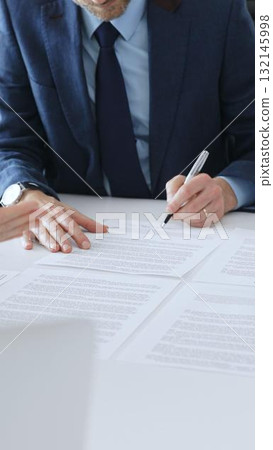 Businessman signing a contract papers at the white desk in office, colleagues applauding to the successful results of negotiations. Business people concept 132145998