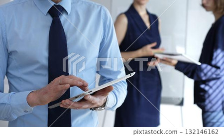 Business professional navigating a tablet, touching screen to access data and collaborate in a modern corporate office, showcasing mobile technology and teamwork efficiency Business professional navigating a tablet, touching screen to access data and collaborate in a modern corporate office, showcasing mobile technology and teamwork efficiency 132146162