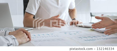 Professional business team reviewing financial data, collaborating over charts and graphs with laptop and pen in contemporary workplace, emphasizing strategic analysis and teamwork 132146334
