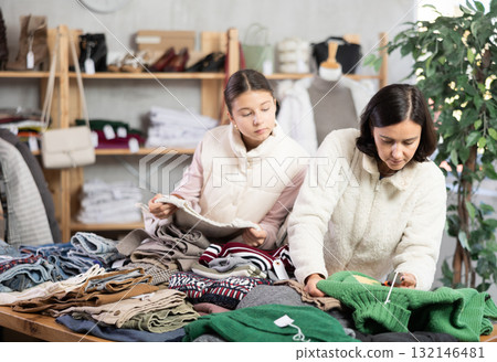 Adult woman and teenage girl choose sweater Adult woman and teenage girl choose sweater 132146481