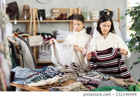 Adult woman and teenage girl choose sweater Adult woman and teenage girl choose sweater 132146484