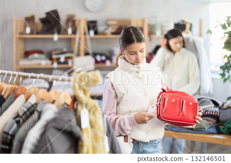 Teenage girl choosing handbag in clothing store 132146501