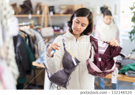 Woman looks at products in store and selects bra. Family shopping 132146520