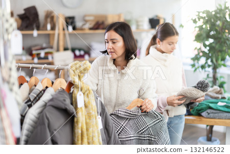 Adult woman and teenage girl choose hat Adult woman and teenage girl choose hat 132146522