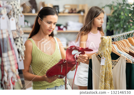 Woman customer choose handbag in store Woman customer choose handbag in store 132146530