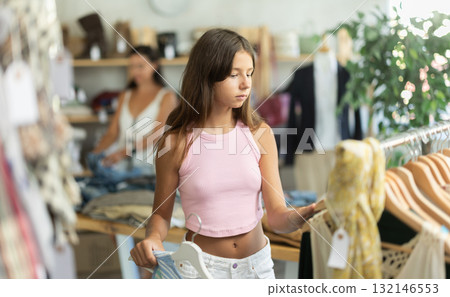Teenage girl customer choose summer tank top in store, Teenage girl customer choose summer tank top in store, 132146553