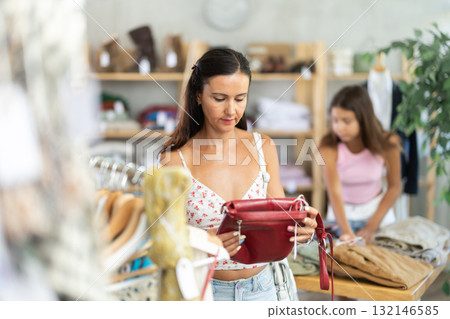 Woman customer choose handbag in store Woman customer choose handbag in store 132146585